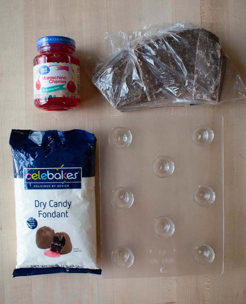 Cherry cordial supplies including chocolate, canned cherries, powdered fondant, and plastic candy mold