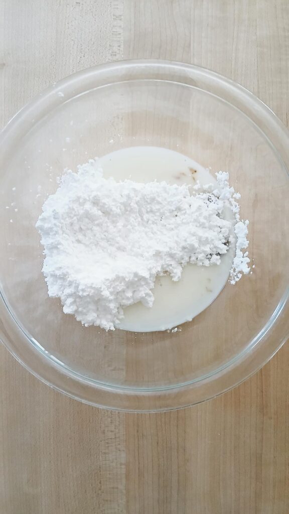 Milk and powdered sugar in a glass bowl ready to be mixed in order to make a glaze
