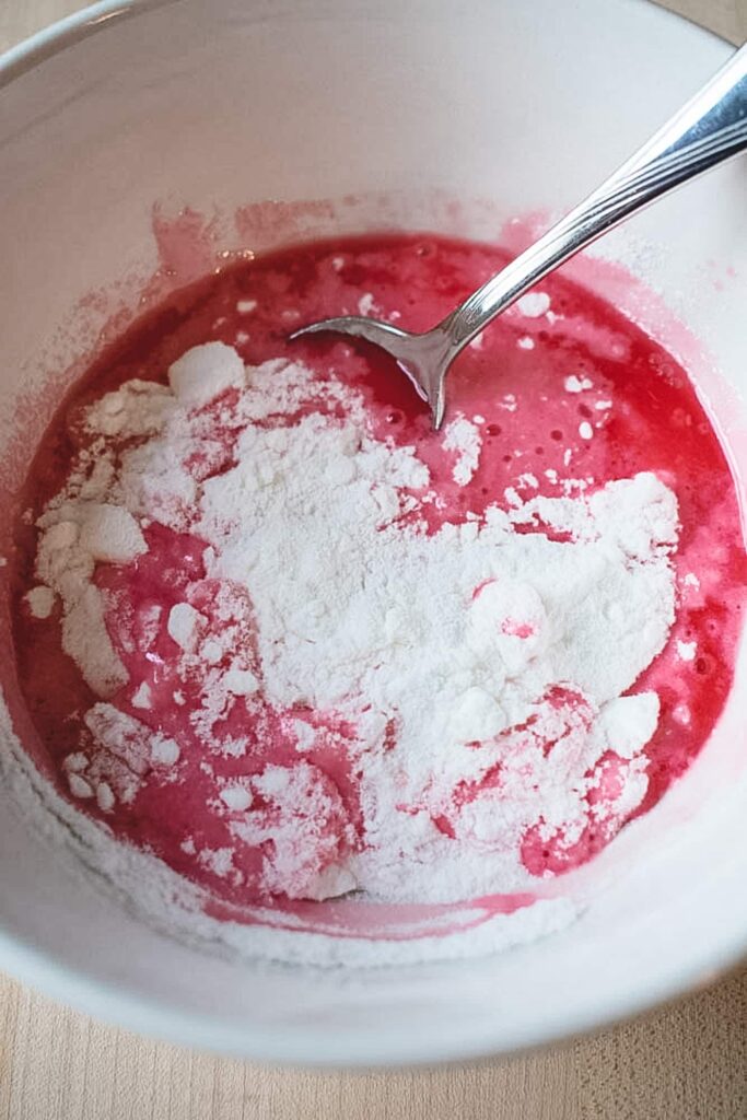 Mixing white powdered fondant with cherry juice to make the filling for chocolate covered cherries