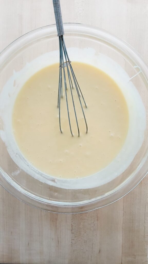 Egg yolks and condensed milk mixed together as part of making lemon icebox pie filling