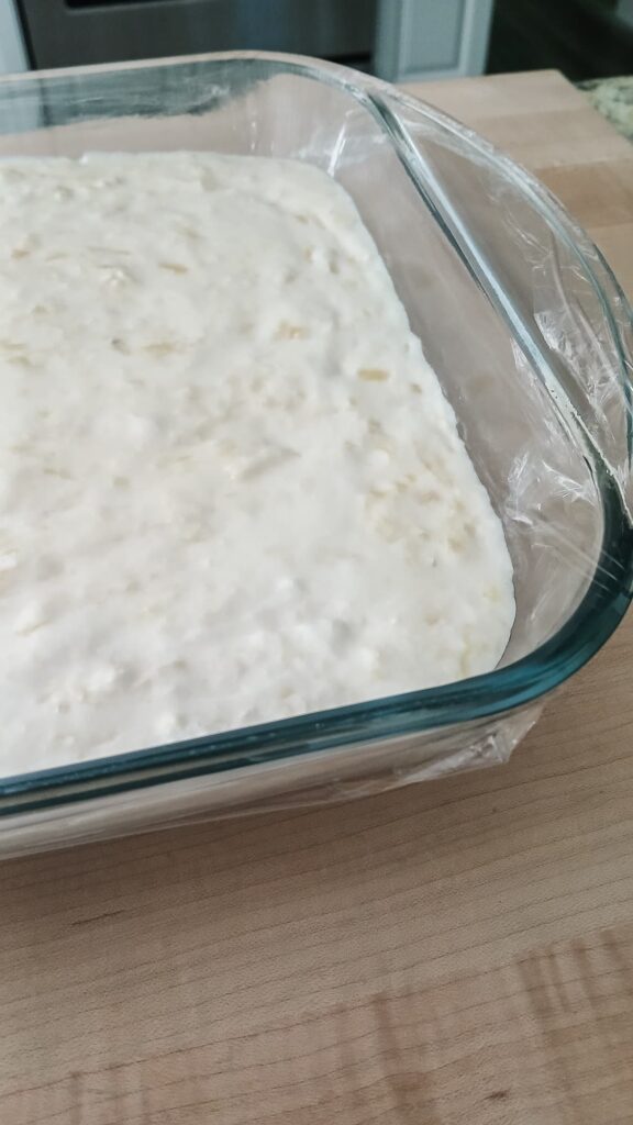 Light and fluffy pineapple filling poured on top of cooled crust. Baking pan is wrapped in plastic wrap and ready to chill