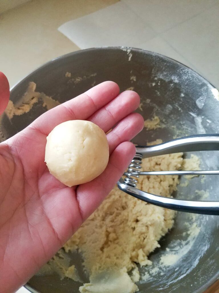 Showing the size of a 40-gram snickerdoodle dough ball in hand before rolling in cinnamon sugar for a soft and pillowy result
