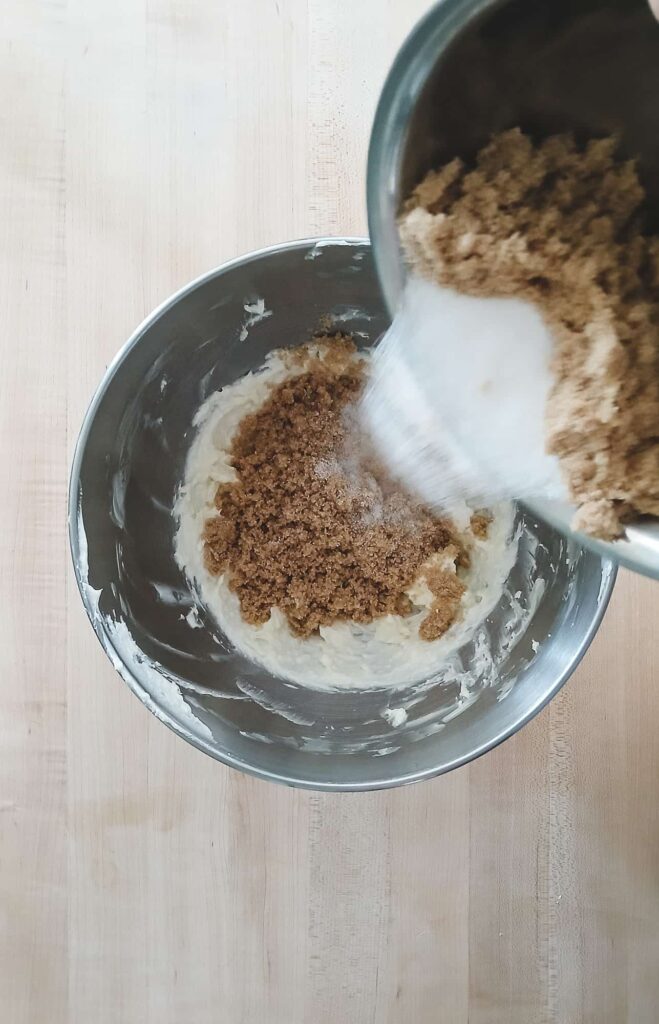 Light brown and granulated sugar being added into a butter and shortening mixture
