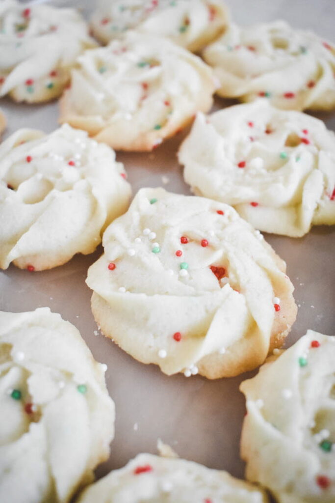 Baked whipped shortbread rosettes topped with festive multi-colored sprinkles, illustrating a popular variation for different holidays or special occasions.